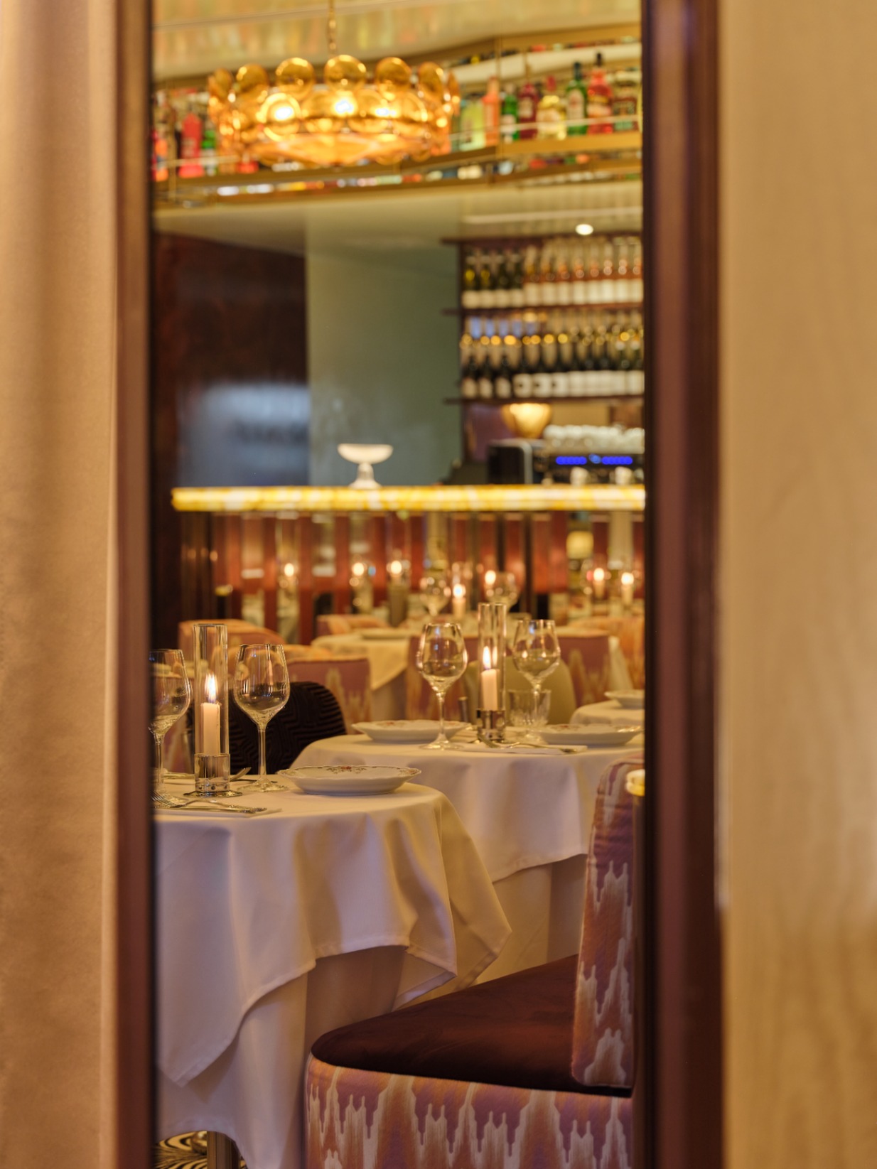 Dining room view framed through a doorway with candlelit tables